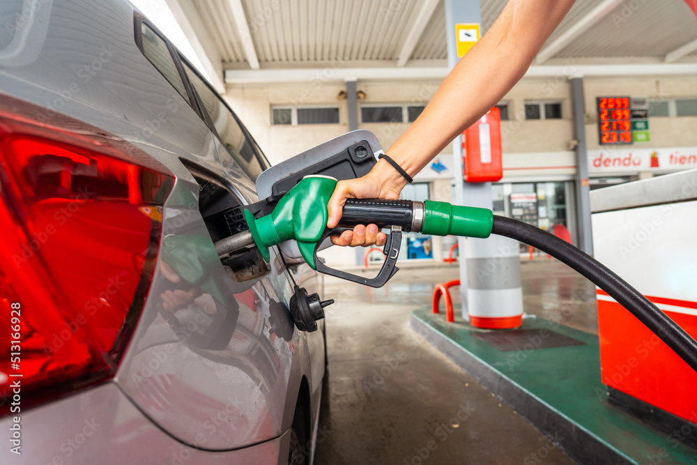 Woman refueling gasoline at gas station in fuel crisis after war conflict Woman refueling gasoline at gas station in fuel crisis after war conflict
