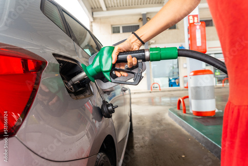 Obraz na płótnie Woman refueling gasoline at gas station in fuel crisis. gray car