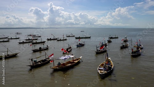 Fishing boats with Indonesian flags leaning on Kenjeran beach in the morning. photo