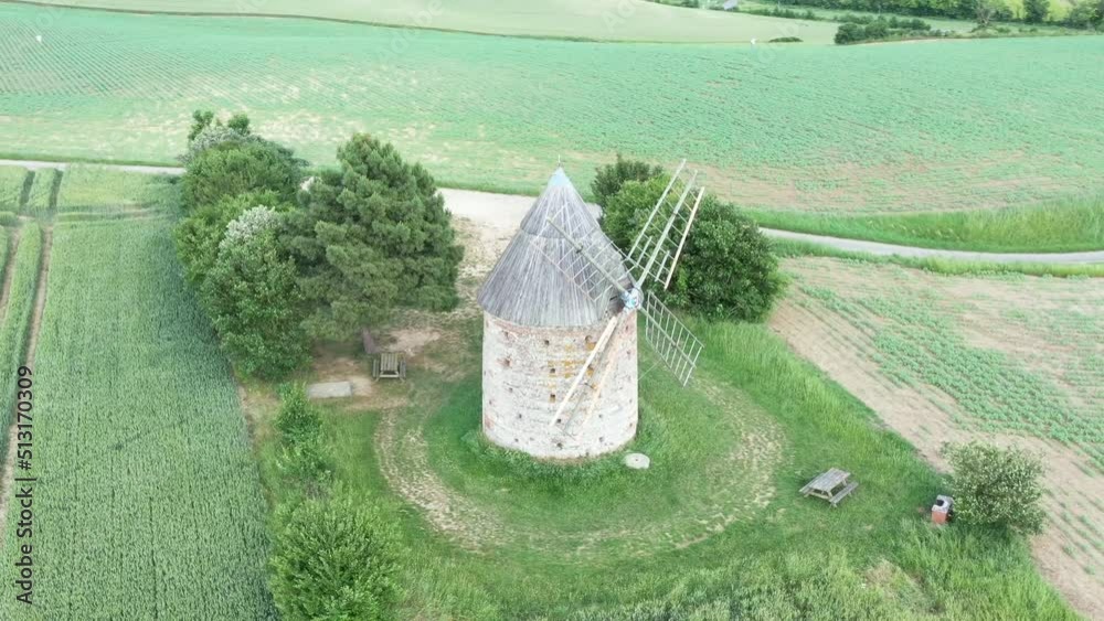 moulin à vent et champ de blé surplombant la campagne française	
