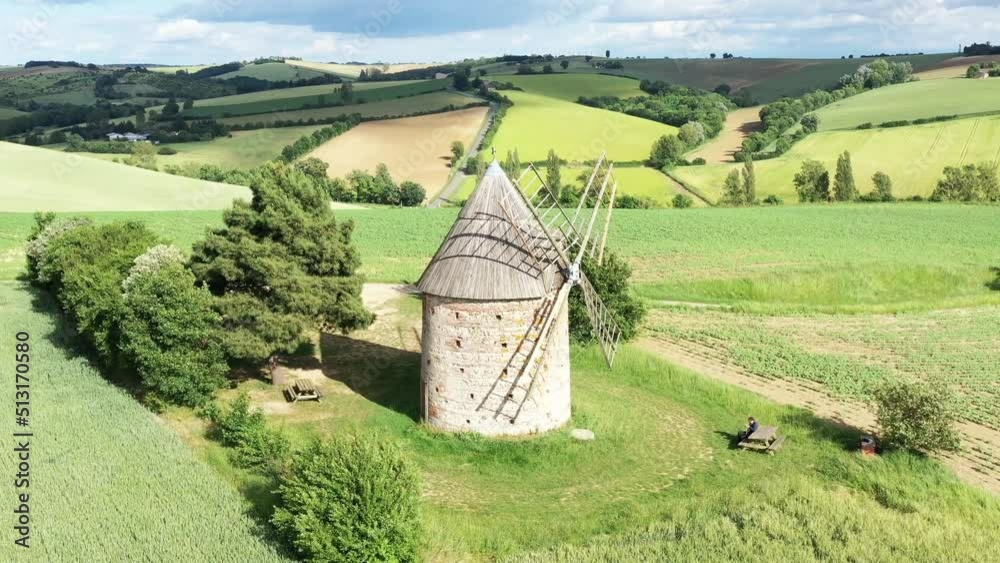 moulin à vent et champ de blé surplombant la campagne française	
