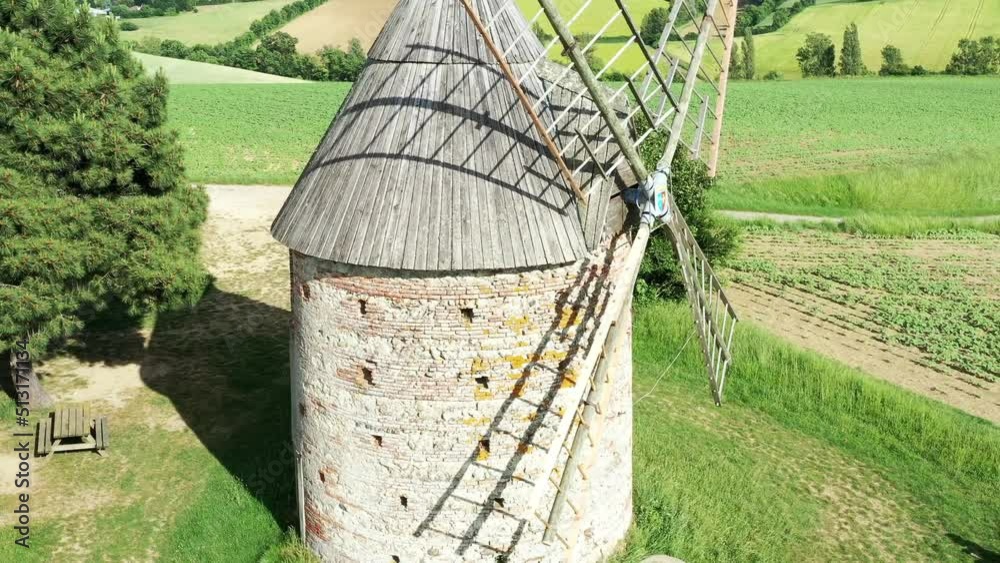 moulin à vent et champ de blé surplombant la campagne française	
