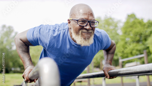 Tablou canvas Healthy senior black male doing push ups on bars outdoors