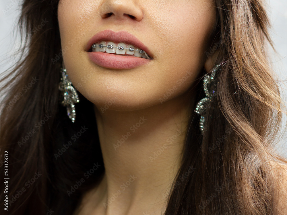 Close-up of sexy female lips with tongue. Clean skin and a clear lip contour are outlined with a fashionable pink lipstick. White teeth and the beauty of smile for stamotologii, spa or cosmetology