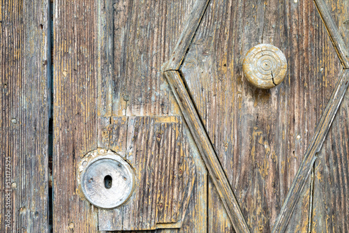 Dettaglio di serratura e maniglia di antica porta chiusa di vecchia chiesa. Porta di legno marrone corrosa dal tempo. photo