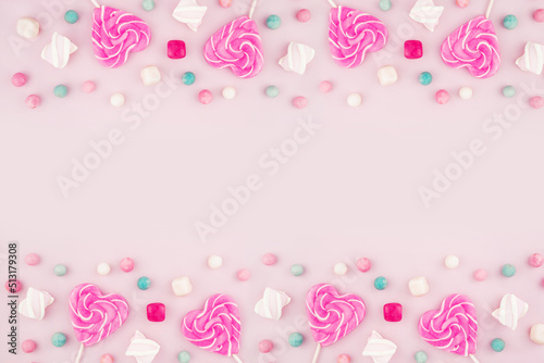 Pink lollipops, candy, caramel and marshmallows. Bright sweets and Valentine's Day. Top view flat surface with space to copy