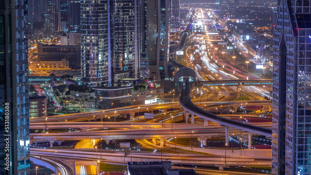Busy Sheikh Zayed Road intersection aerial night timelapse, metro railway and modern skyscrapers around in luxury Dubai city. Busy Sheikh Zayed Road intersection aerial night timelapse, metro railway and modern skyscrapers around in luxury Dubai city.