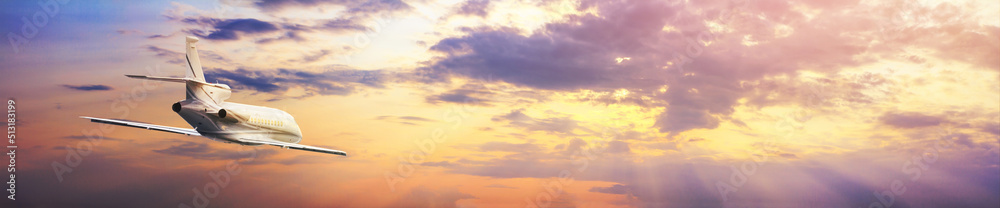 Modern corporate business jet during flight against the background of the sunset sky. Horizontal banner with free copy space for text