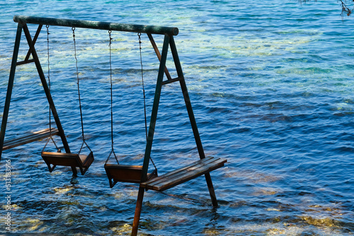 Blue sea and romantic double iron swing located in the corner. Simple, interesting decorating idea for resorts. Selective Focus