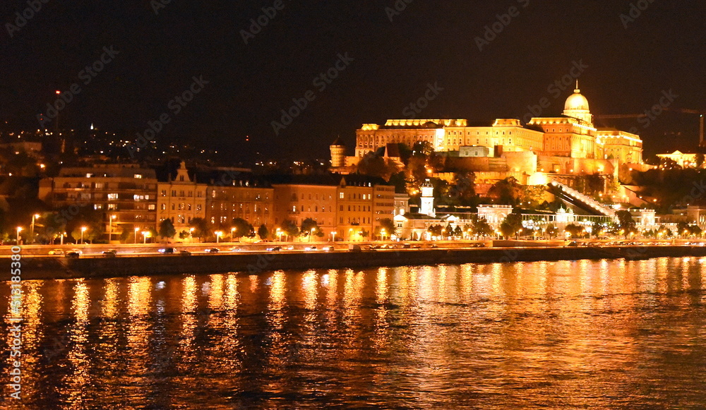Hell beleuchteter Burgpalast am Ufer der nächtlichen Donau
