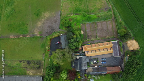 drone shot lush landscape horses and farmhouse