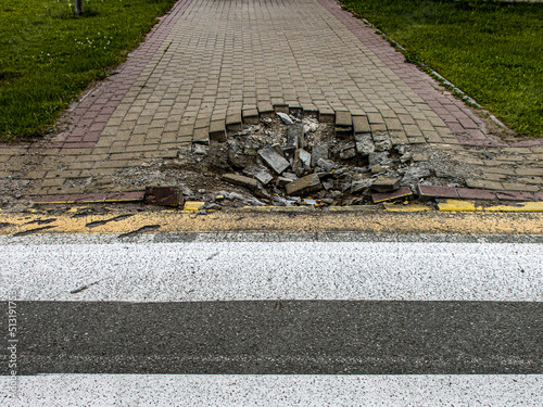 BUCHA, UKRAINE - June 20, 2022: crater funnel from a snard explosion at a crosswalk, sidewalk, asphalt