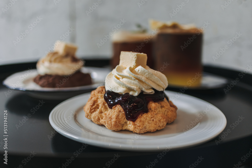 Dessert set of scones and americano coffee for couple served in cafe. Dessert set of scones and americano coffee for couple served in cafe.