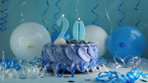 Happy twentieth birthday navy cake and number twenty candle with blue balloons photo