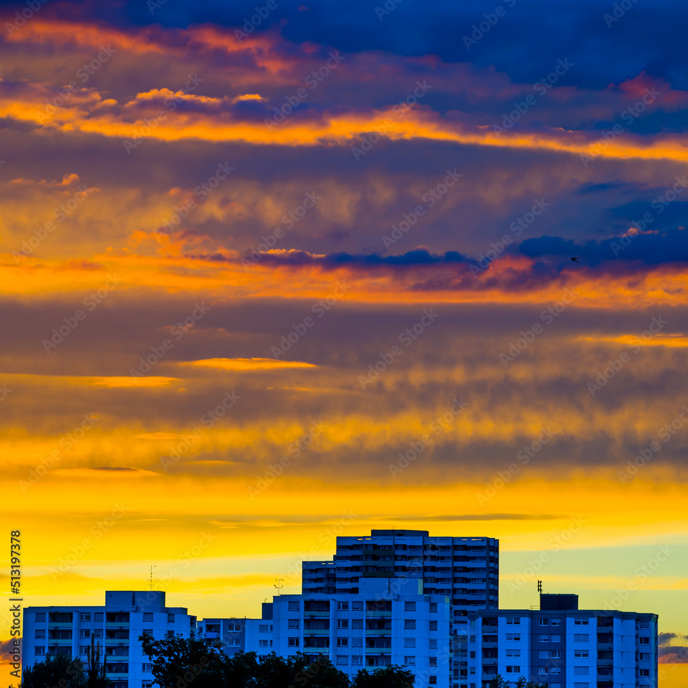 Multicolored sunset sky over city buildings