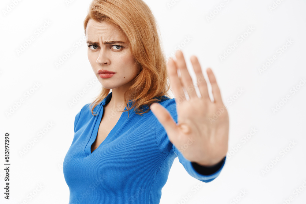 Portrait of girl extending her palm, saying no, dislike smth, prohibit, rejecting offer, standing over white background Portrait of girl extending her palm, saying no, dislike smth, prohibit, rejecting offer, standing over white background