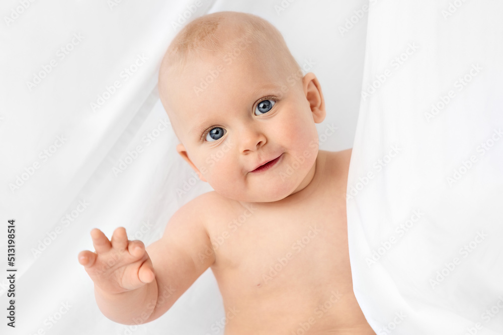 Portrait of blue-eyed baby peeking behind white sheet Portrait of blue-eyed baby peeking behind white sheet