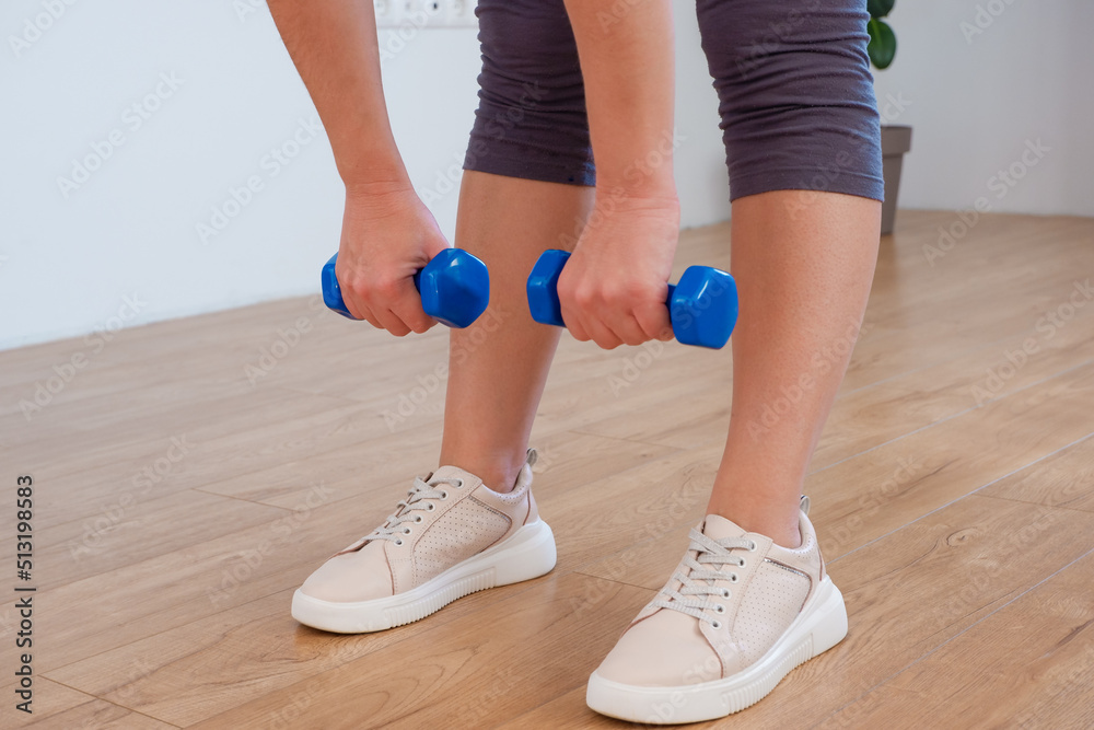 sportswoman practicing aerobic with dumbbells. woman lifting weights and working out at home. sportswoman practicing aerobic with dumbbells. woman lifting weights and working out at home.