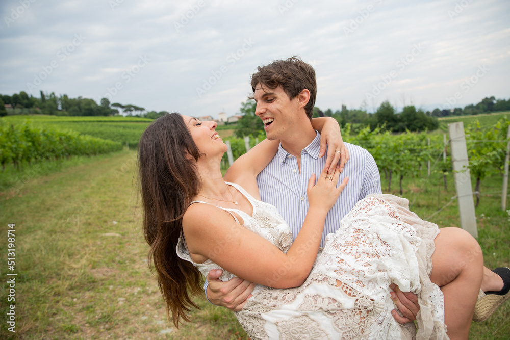 Girl in love gets picked up by her love in an outdoor field. Love concept Girl in love gets picked up by her love in an outdoor field. Love concept
