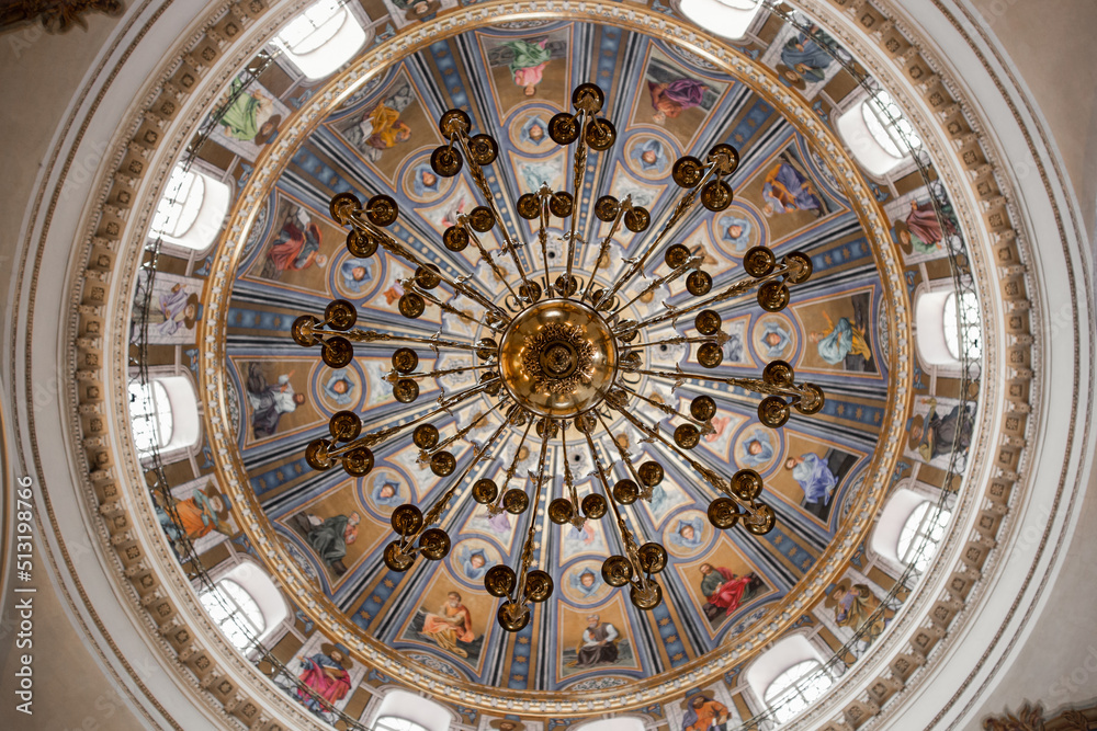 beautiful chandelier on a round painted ceiling in a catholic church