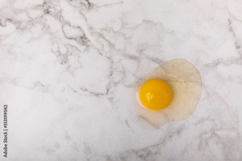 Broken quail egg on the surface. Quail eggs on a white marble background. Natural products. Place for text. fresh eggs Broken quail egg on the surface. Quail eggs on a white marble background. Natural products. Place for text. fresh eggs