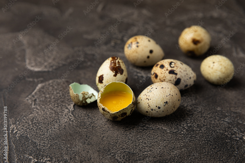Obraz premium Quail eggs on a black texture background. Whole and broken quail eggs. Natural products. Place for text. Fresh quail eggs.