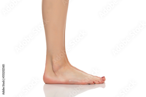 Side view of beautifully cared women's feet on white background