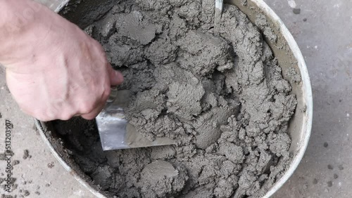 Mixing of concrete mortar.The builder prepares the cement mortar using a construction trowel.Plaster mortar in a bucket.