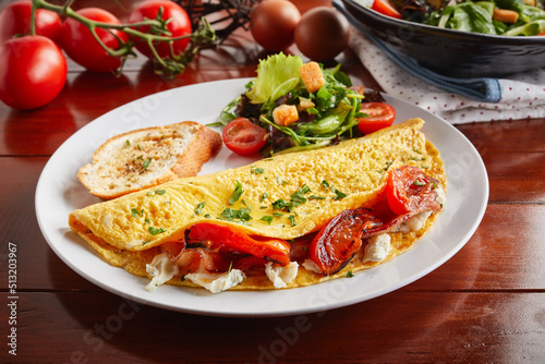 Greek Style cream sauce omelette roll with salad served in a dish isolated on wooden background side view