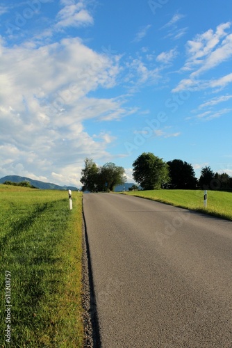 Kurvige Landstraße, die einen Hügel hinauf führt. Alpenvorland, Allgäu, Bayern