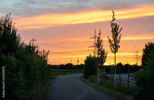 a beautiful atmospheric red sunset on a field with power poles photo