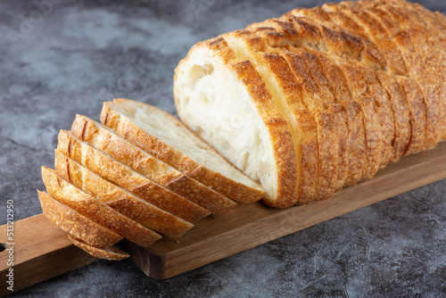 Fresh white loaf of bread on gray cement background. Top view