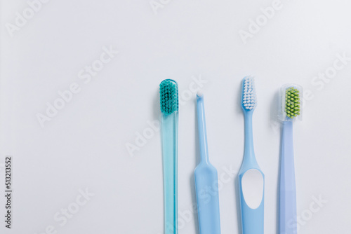 Four toothbrushes at different heights on a white background