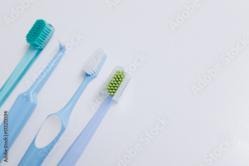 Four toothbrushes at different heights on a white background. Place for your text