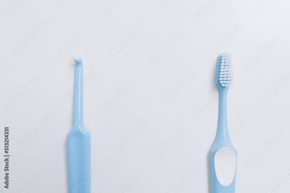 Two blue toothbrushes at different distances on a white background Two blue toothbrushes at different distances on a white background