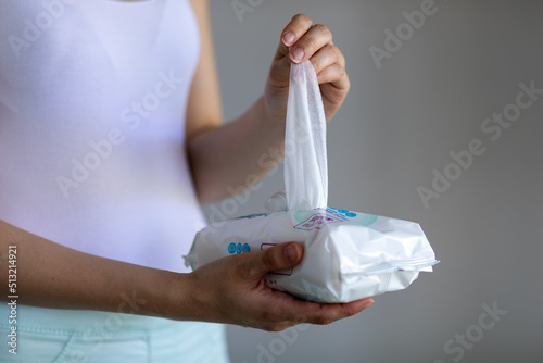 Woman taking wet baby wipes from the packaging - care for clean skin and surfaces