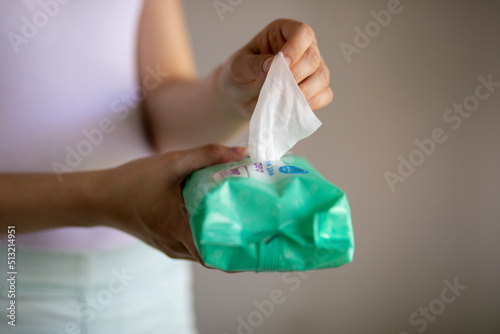 Woman taking wet baby wipes from the packaging - care for clean skin and surfaces