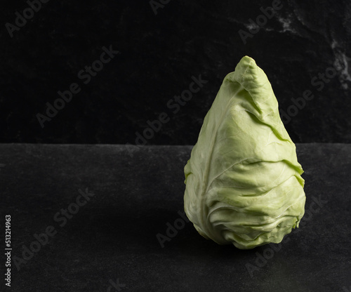 Cone head cabbage for dietary, vegan on a dark background