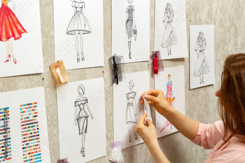 Dress design creates sketches. The fashion designer of women's fashion clothes develops a style. The seamstress is working.