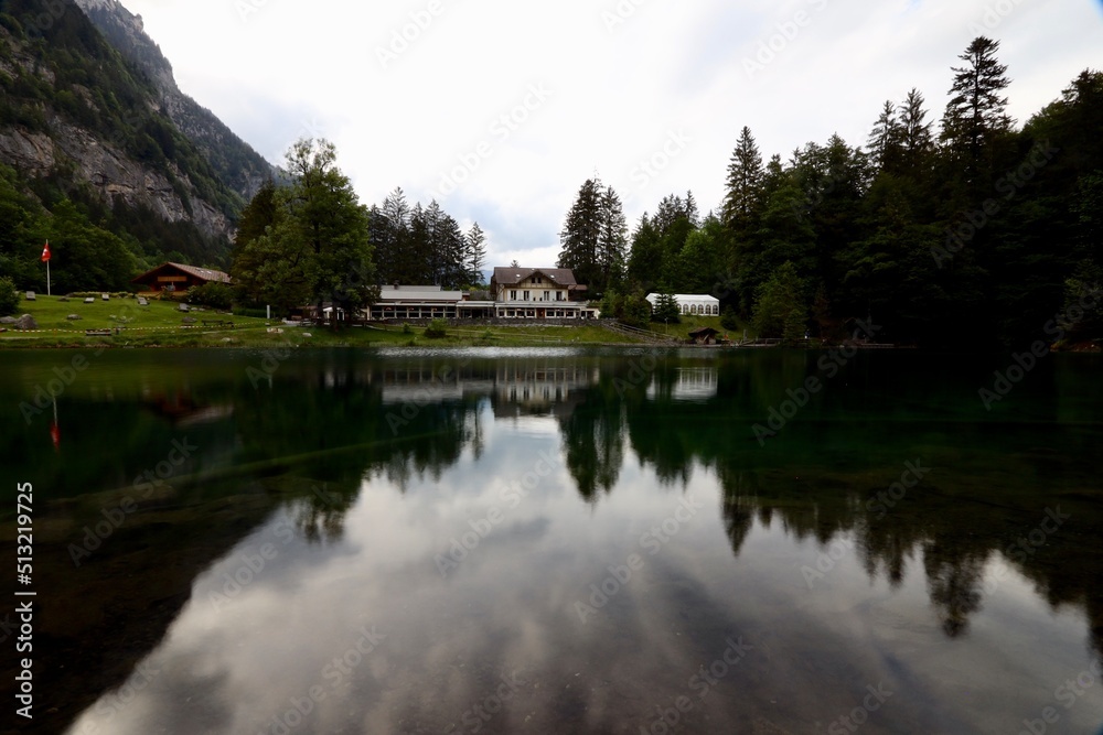 reflection in the water of a house at blausee bern Switzerland reflection in the water of a house at blausee bern Switzerland
