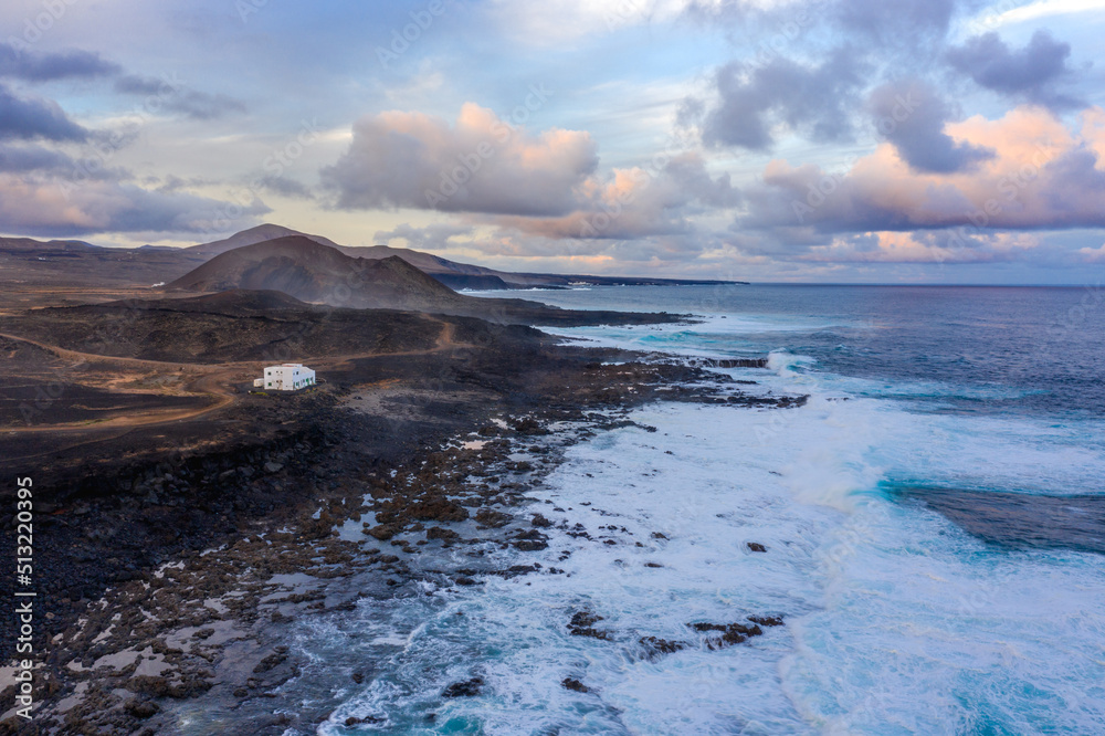 aerial view on volcano and mountains on coast with ocean waves on lanzarote