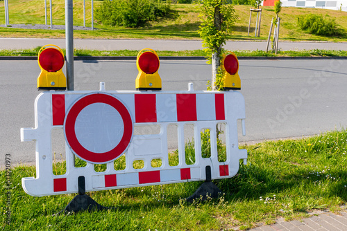 White red plastic barrier with stop signal. Against the background of the road. photo