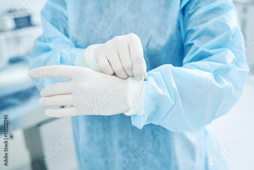 Unrecognized doctor in protective uniform preparing for surgery