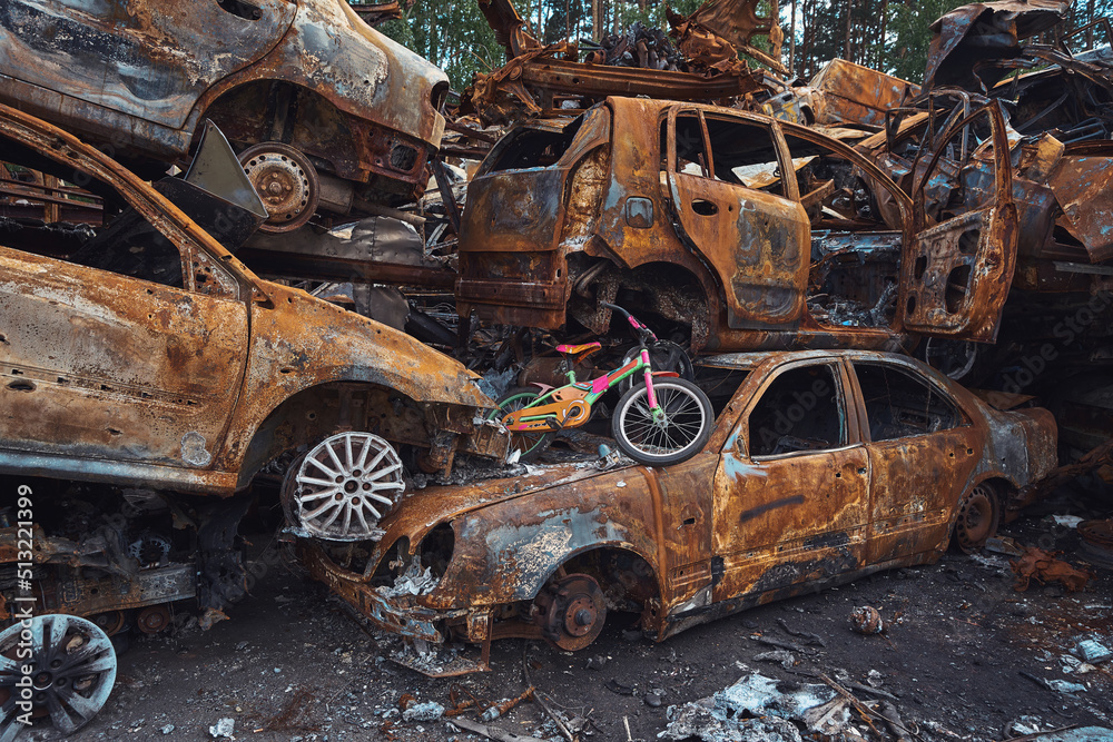 Demolished cars and kids electric bicycles piled up in Irpin