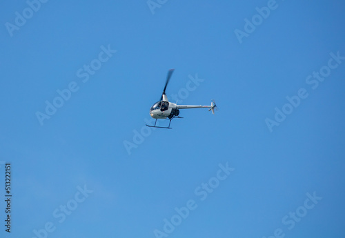 A Small Helicopter flying in a Blue Sky