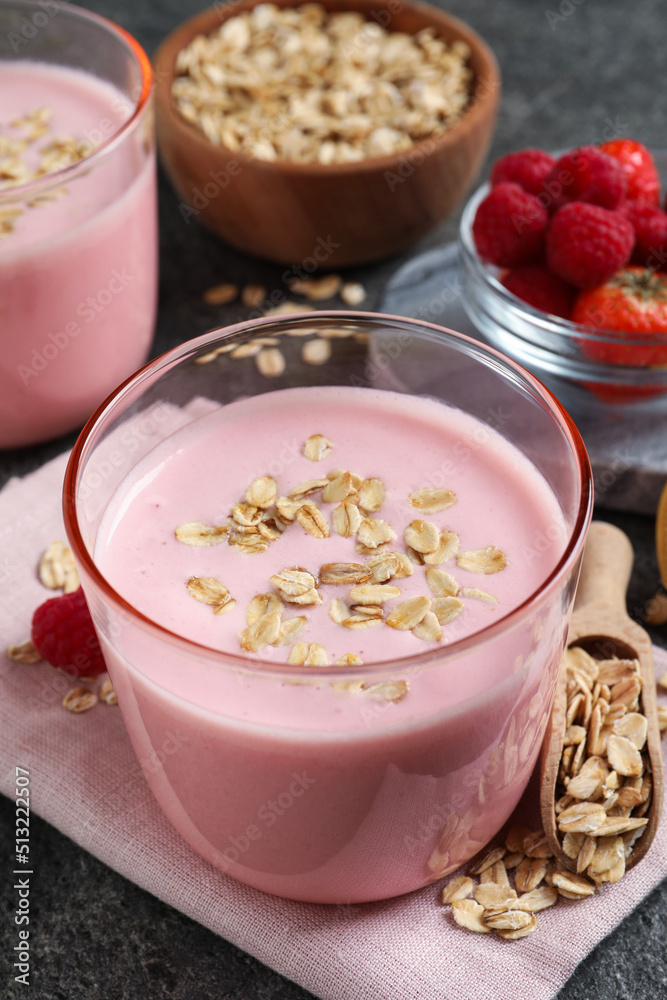 Glass of tasty berry smoothie with oatmeal on grey table, closeup Glass of tasty berry smoothie with oatmeal on grey table, closeup