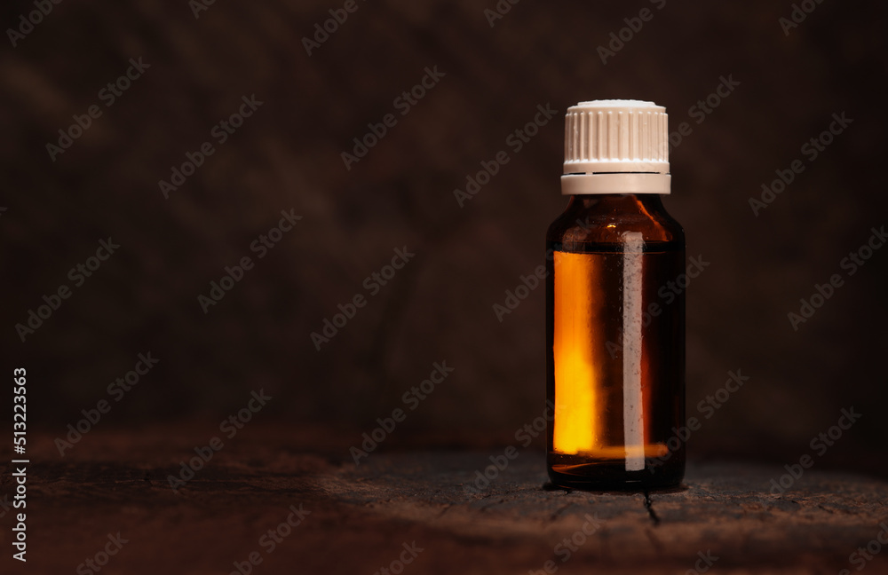 Mockup of an amber glass bottle on a wooden table. Dark, old wood - natural healing, medical product Mockup of an amber glass bottle on a wooden table. Dark, old wood - natural healing, medical product