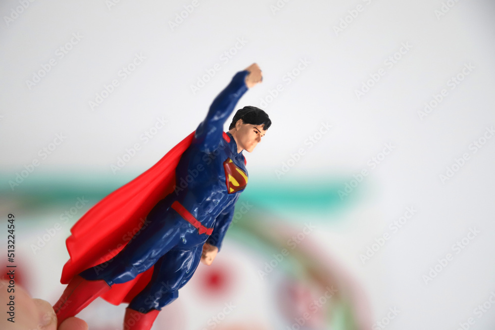 Superman Super Hero. Toy figure. Toy. Classic super hero who flies. Marvel.  DC comics. Planet Krypton. Kryptonite. Boy playing with Superman. Boy  making Superman fly. Photos | Adobe Stock