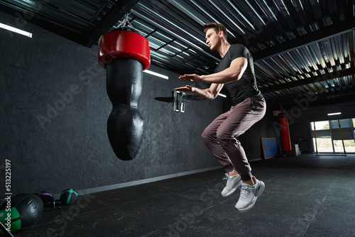 Serious strong athletic male doing plyometric exercise photo