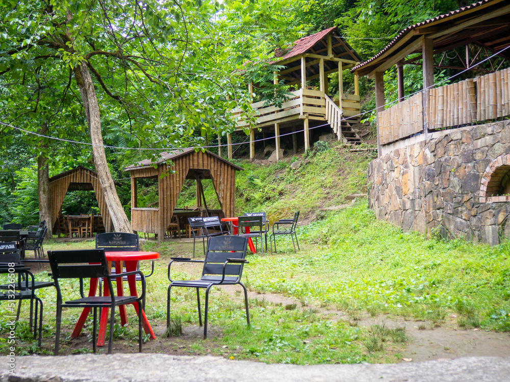 Beautiful restaurant in the mountains. Empty tables of a diner in the woods. Restaurant in nature.